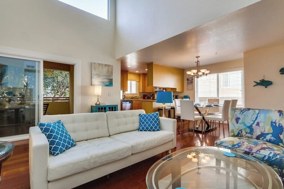 Open floor plan with dining area, living room, sliding glass door to private balcony, and kitchen