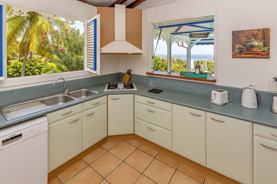 The kitchen of Villa Thera overlooks both the garden and the ocean. Perfect for trying out Creole recipes and sharing them with family and friends.
