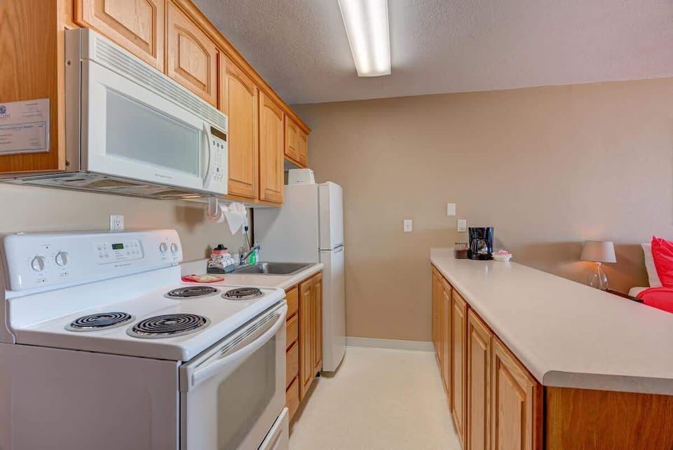 The unit has full-size appliances including a stove, oven, microwave, and fridge