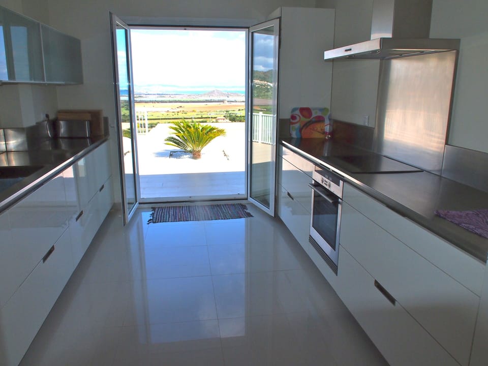 Modern kitchen with doors leading onto Swimming pool terrace