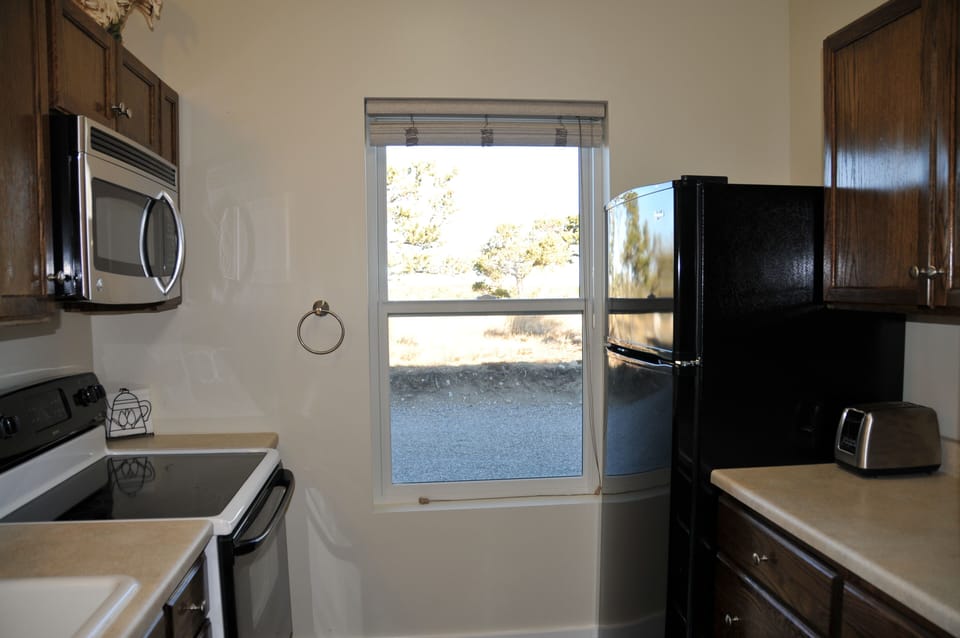 Kitchen with stove, fridge and microwave