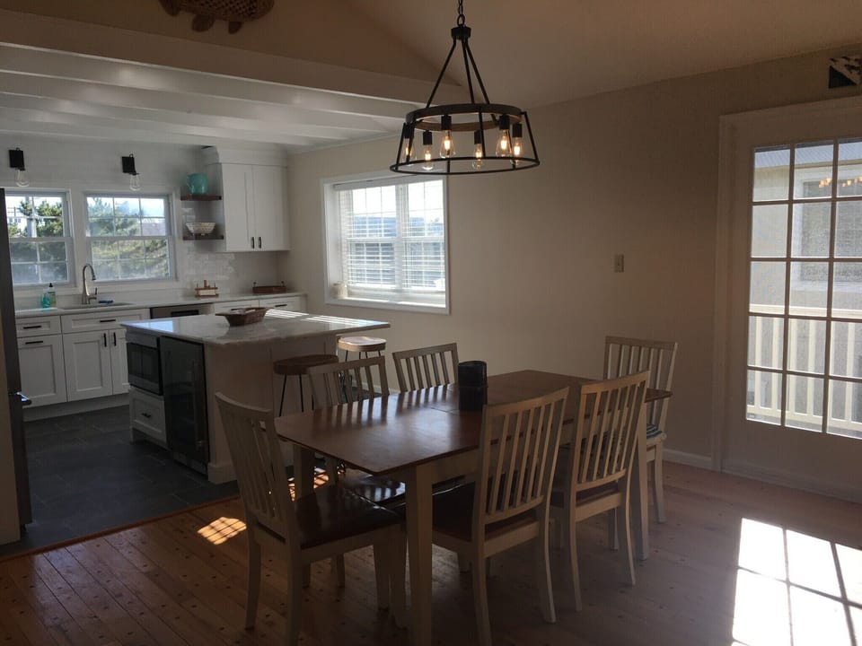 Open dining area to kitchen and doors leading to front and back deck