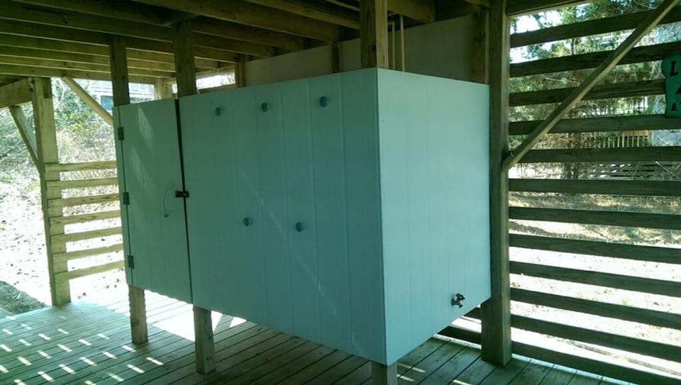 updated outdoor shower with changing space, shelves and towel hooks