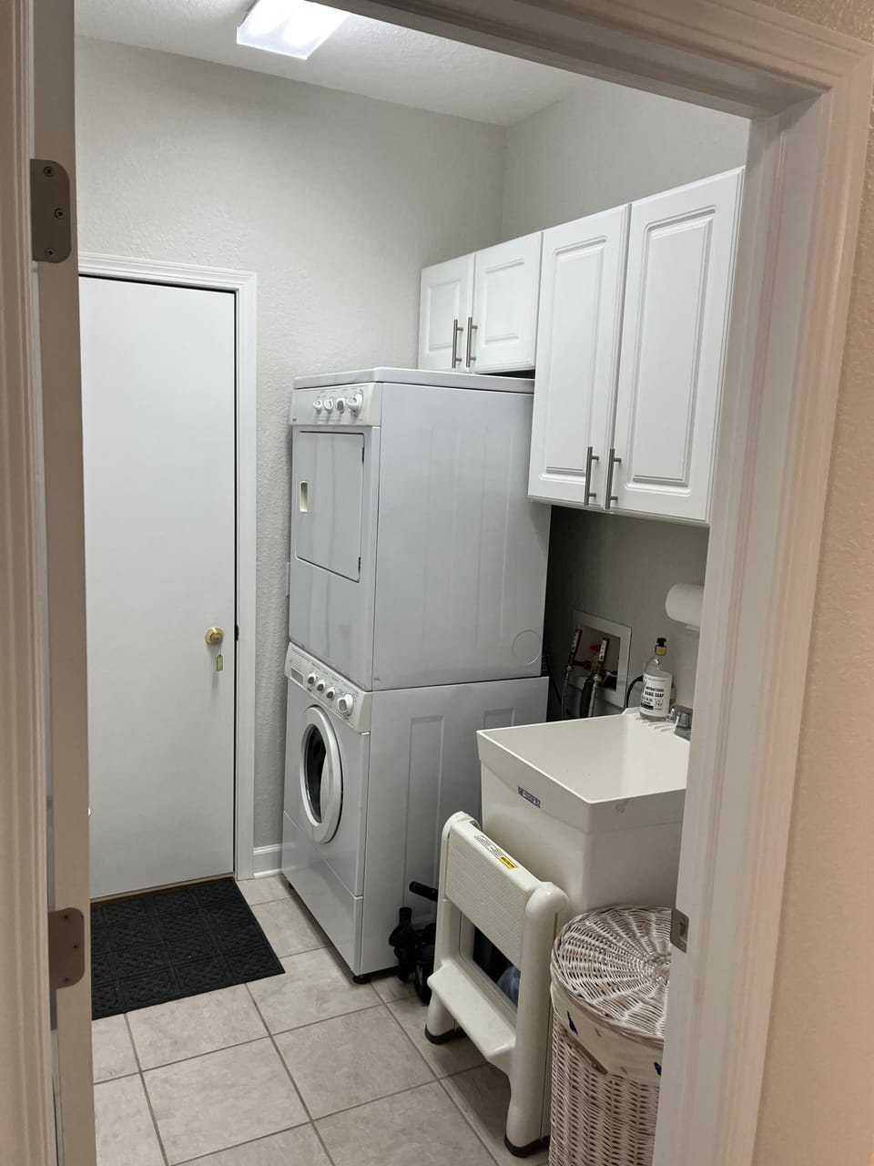 Laundry room equipped with washer, dryer, and tub sink 