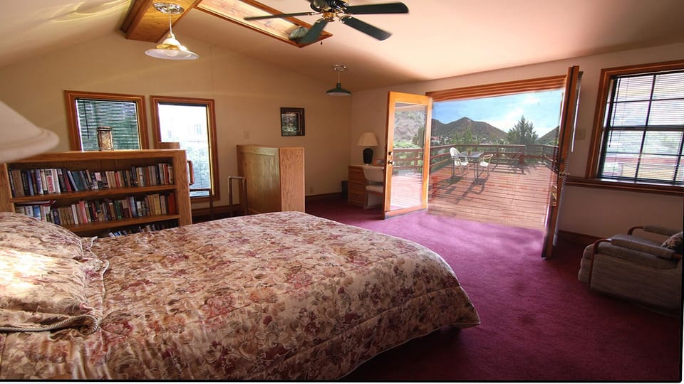 Master bedroom with french doors out to deck and overlooking the town
