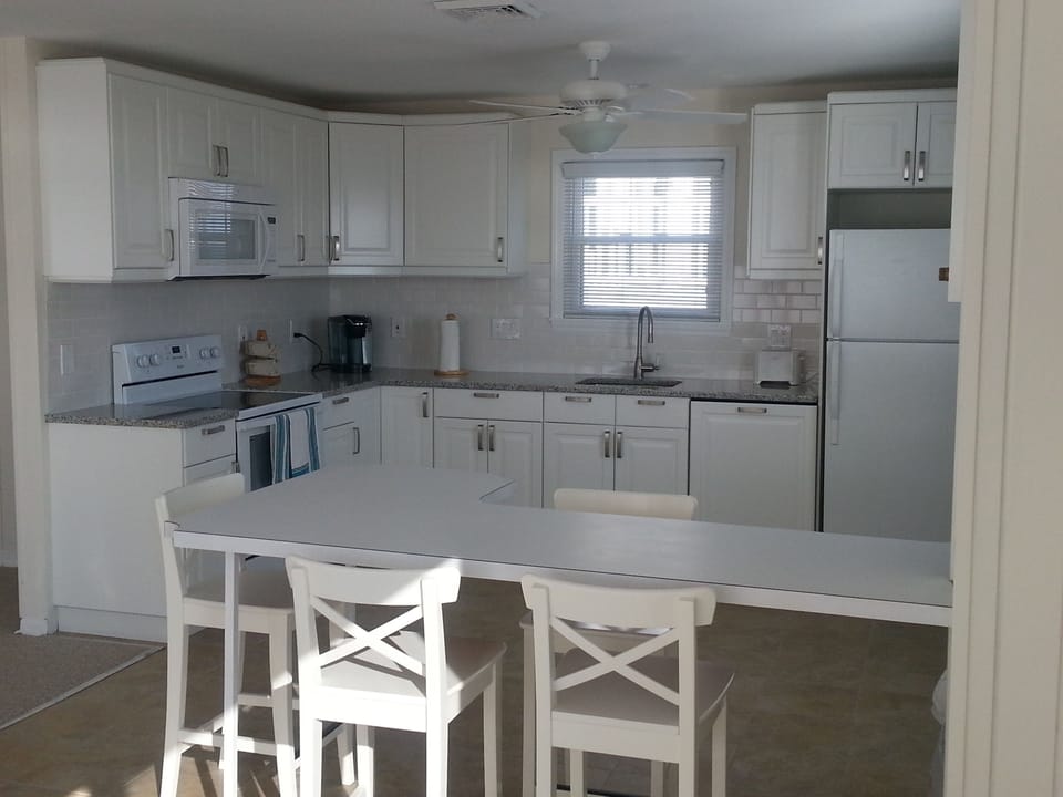 Well-equipped kitchen open to dining area, peninsula seats additional four