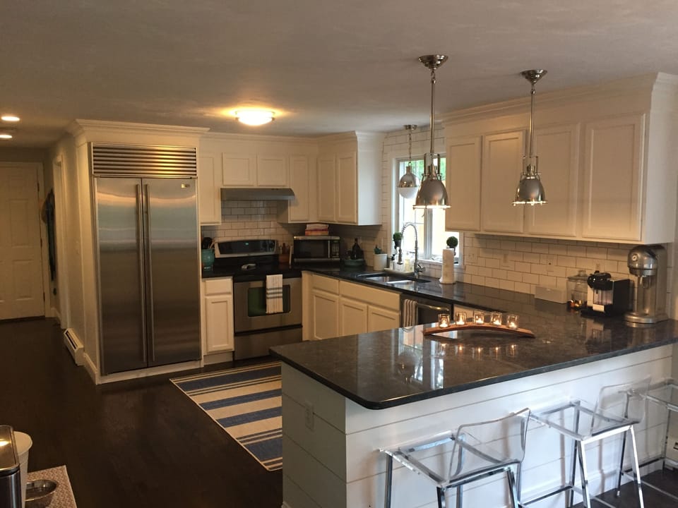 open kitchen with subzero fridge, granite, custom cabinets, pendant lighting