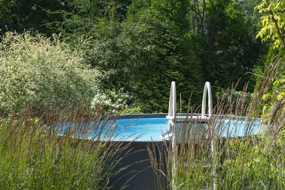 The heated pool, lose to the front deck, is tucked in the flower beds.