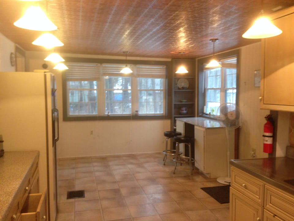 other side of kitchen has bar seating and view of garden
