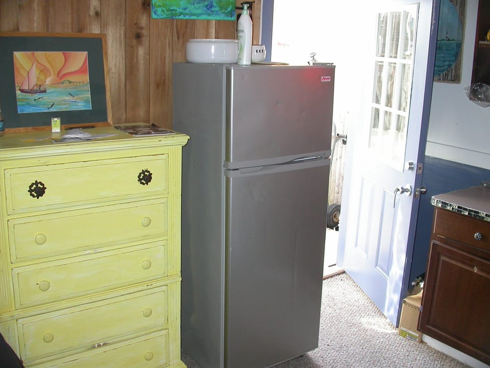 Refrigerator, Microwave Oven, Sink, Kitchen Cabinets, Silverware, Plates