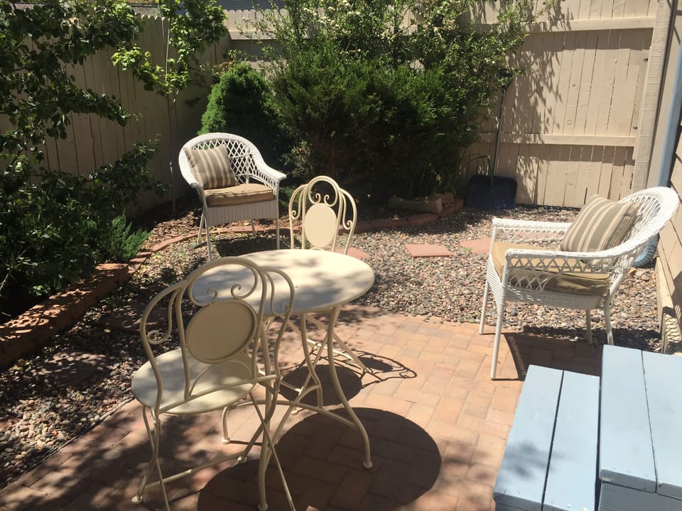 Upper patio bistro set and steps up to patio door into living room/dining room.