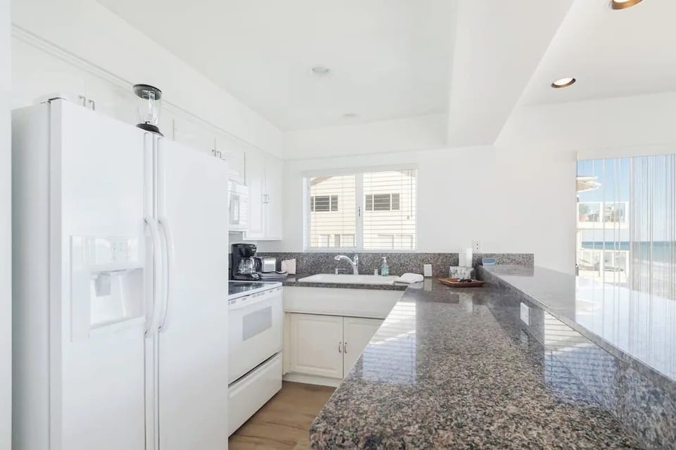 One of two kitchens with a stove, microwave, dishwasher and cooking utensils