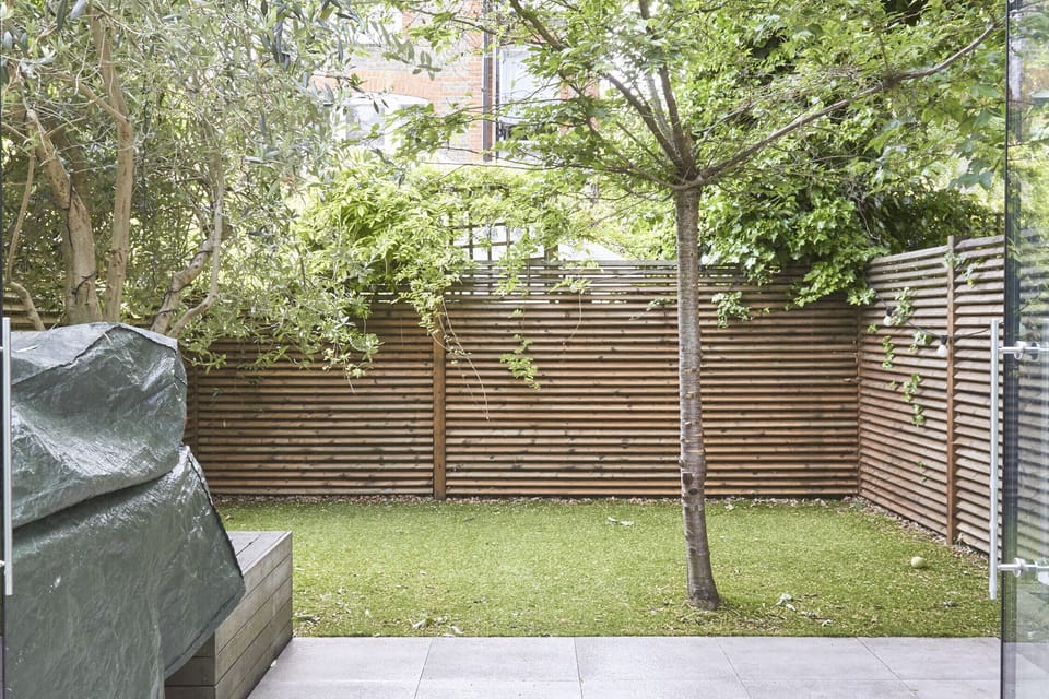 Private south-facing garden with grill and outdoor dining table seating six.