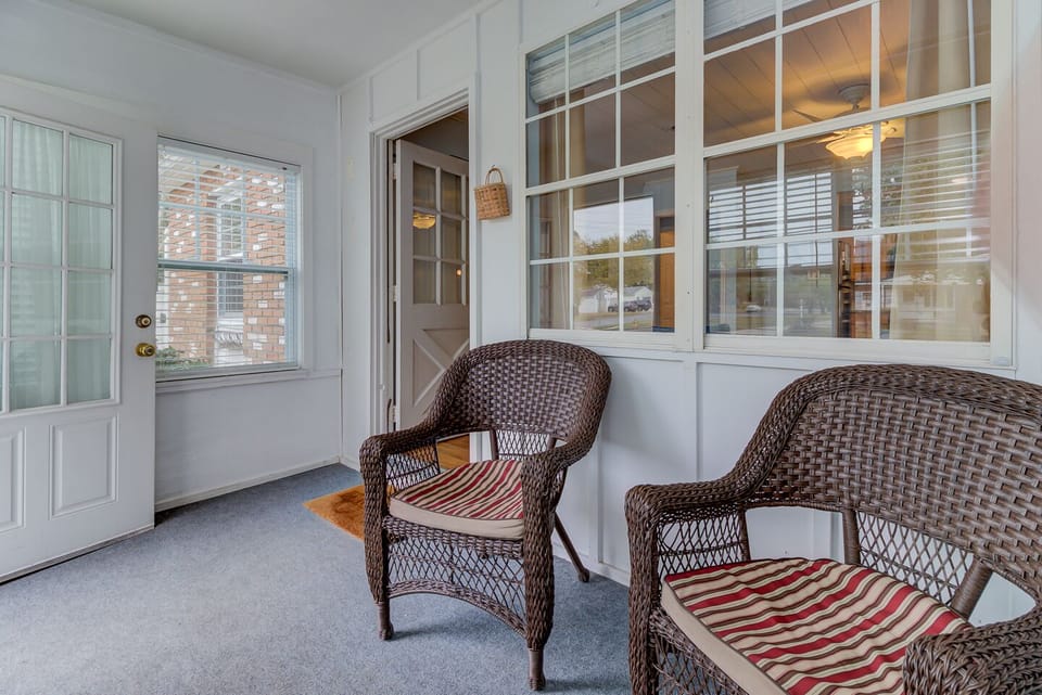 Cozy front porch with walls of windows and a spot for coffee
