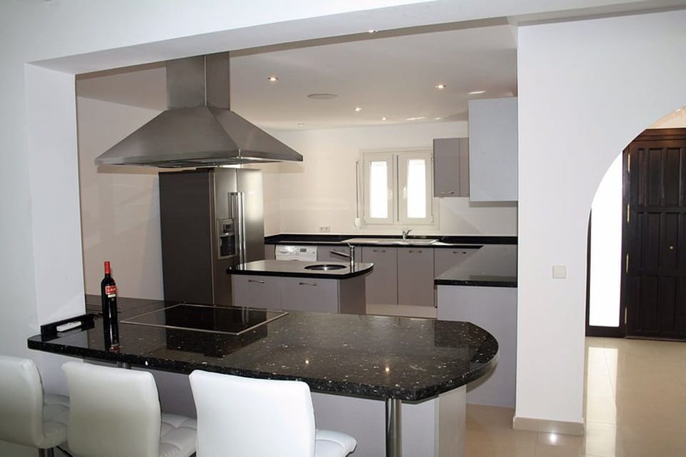 Fully fitted kitchen with barstools and counter area