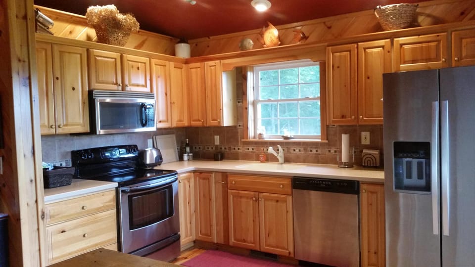 Another view of kitchen, includes smaller appliances, spice rack, soaps & paper.