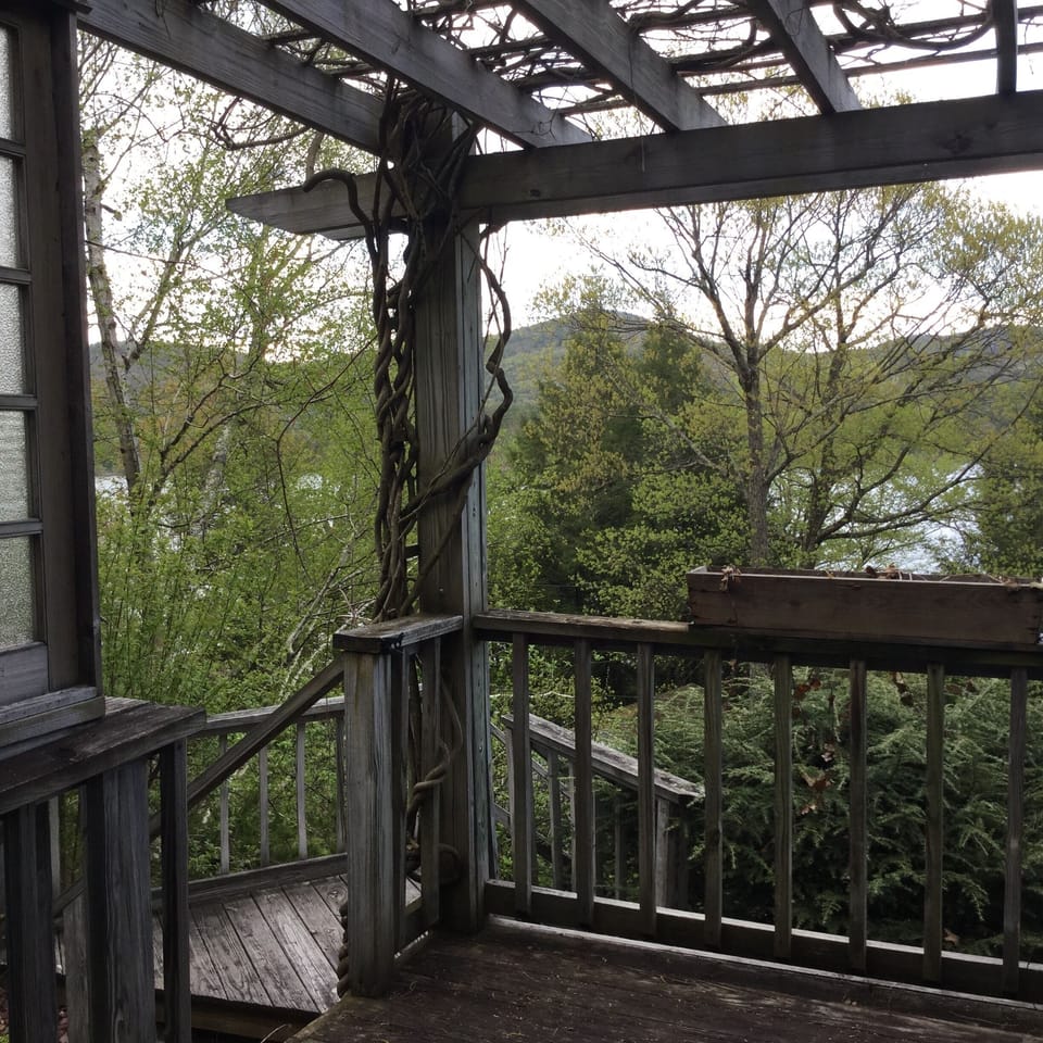 Deck on front of house with steps leading down to the lakefront deck and dock.
