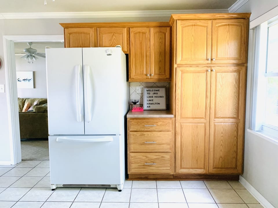 Kitchen has many cabinets and large pantry for food storage. 