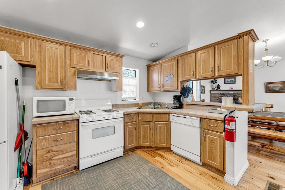 The kitchen is equipped with a stove, microwave, coffee machine, and dishwasher