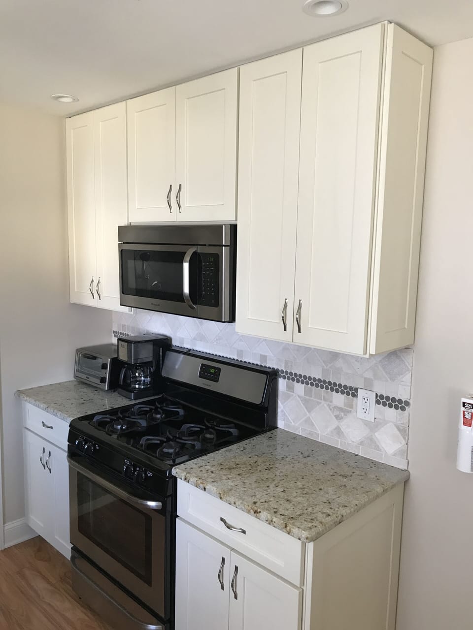 Stainless steel appliances, tile backsplash and granite countertops