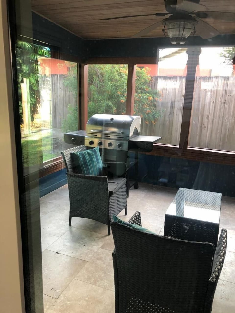 Screened in lanai with comfortable seating and grill