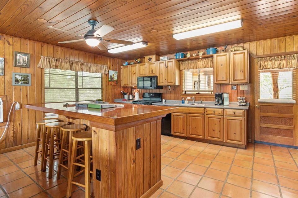 Golden woodwork highlights the main living spaces, giving the living area and kitchen a warm and welcoming glow.