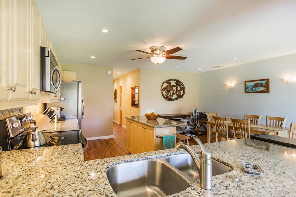 View from family room into kitchen. Check out the nice desk with printer & art!