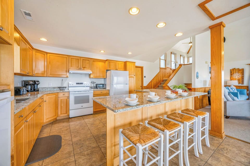Bright, spacious kitchen with granite island, full appliances, and open layout flowing into the living area—perfect for cooking and entertaining.