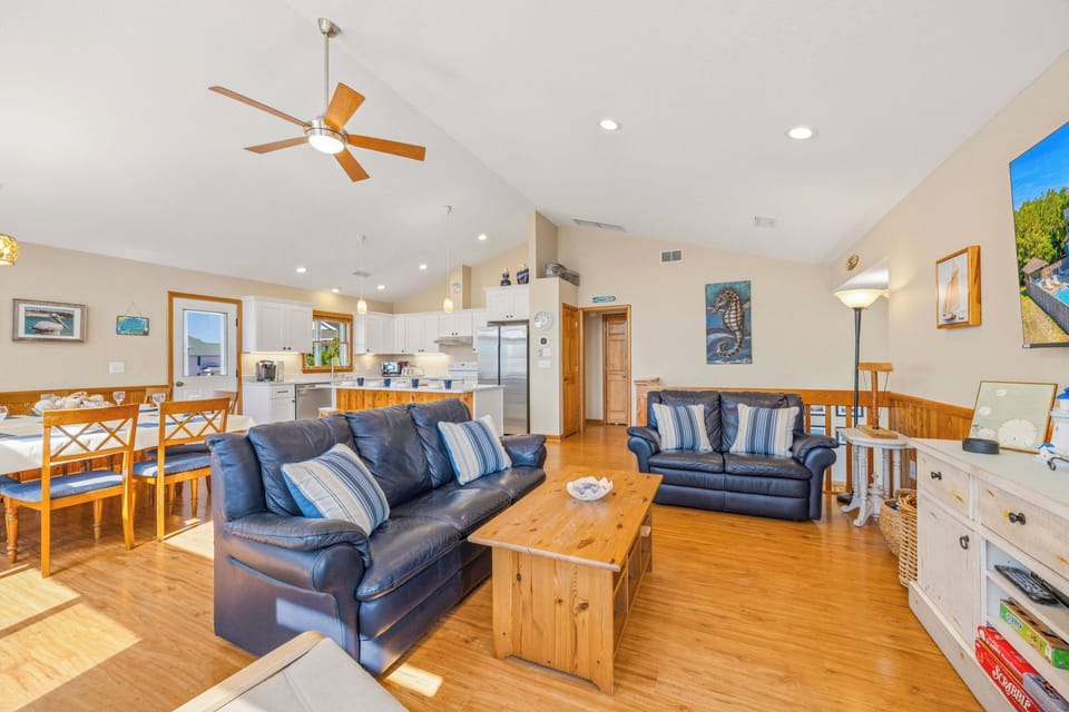 Relax in your bright, airy open-concept living space with soaring ceilings, coastal-themed décor, plush seating, and a fully equipped kitchen—perfect for gathering, unwinding, and creating vacation memories with your loved ones.