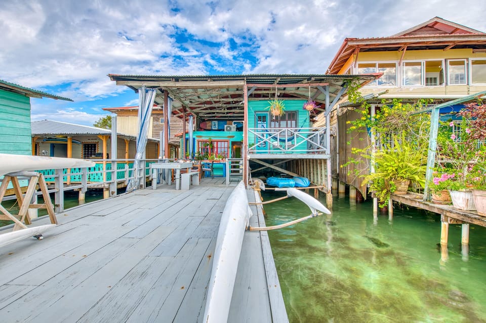 Seaside terrace with three dining tables overlooking the ocean.
