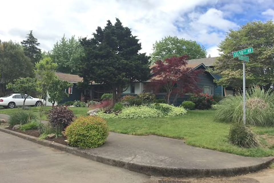 The apartment is behind this main house, which is on a corner lot.