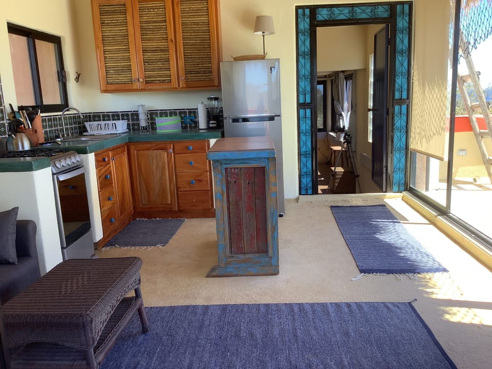 Upstairs kitchen and sitting area with door to bedroom