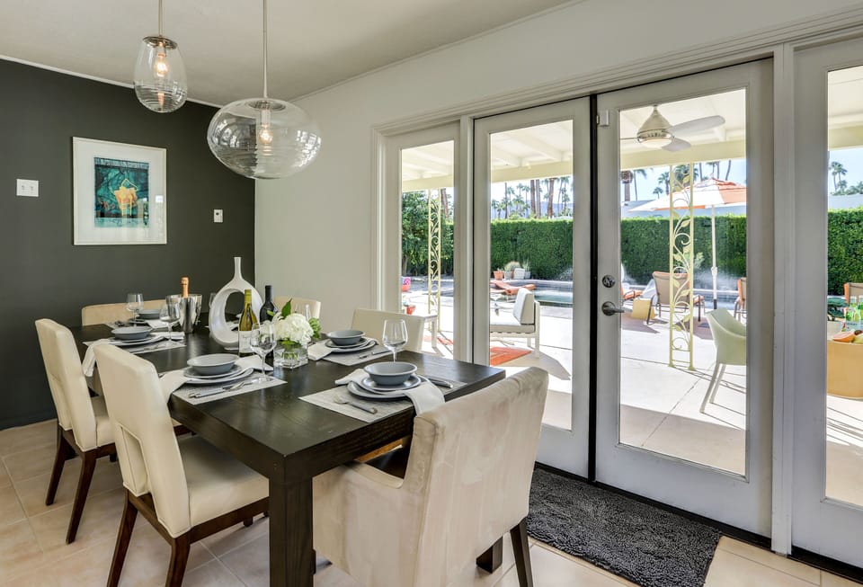 Swanky modern dining area with French door access to pool and backyard oasis