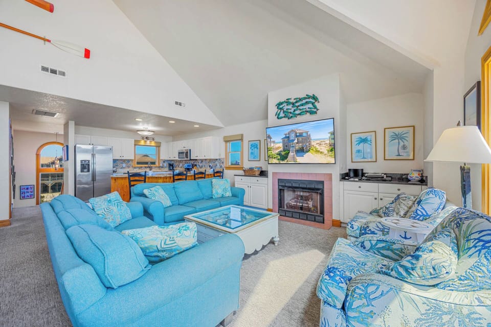 Sink into plush turquoise seating and feel the ocean breeze inspire your stay. Your open kitchen and cozy fireplace await, blending coastal charm with modern ease.
