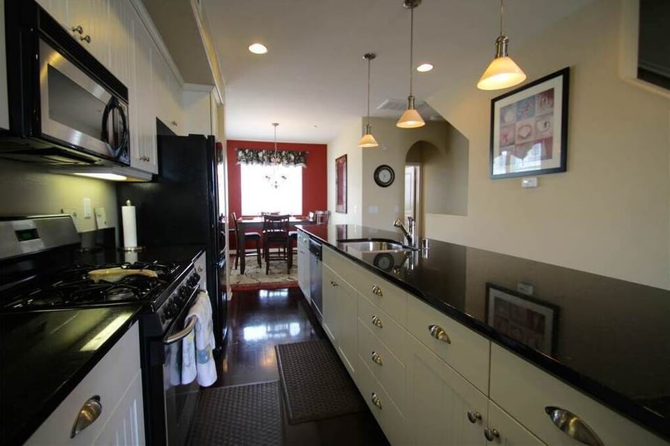 Clean kitchen stocked with dishware, cookware, & appliances you need