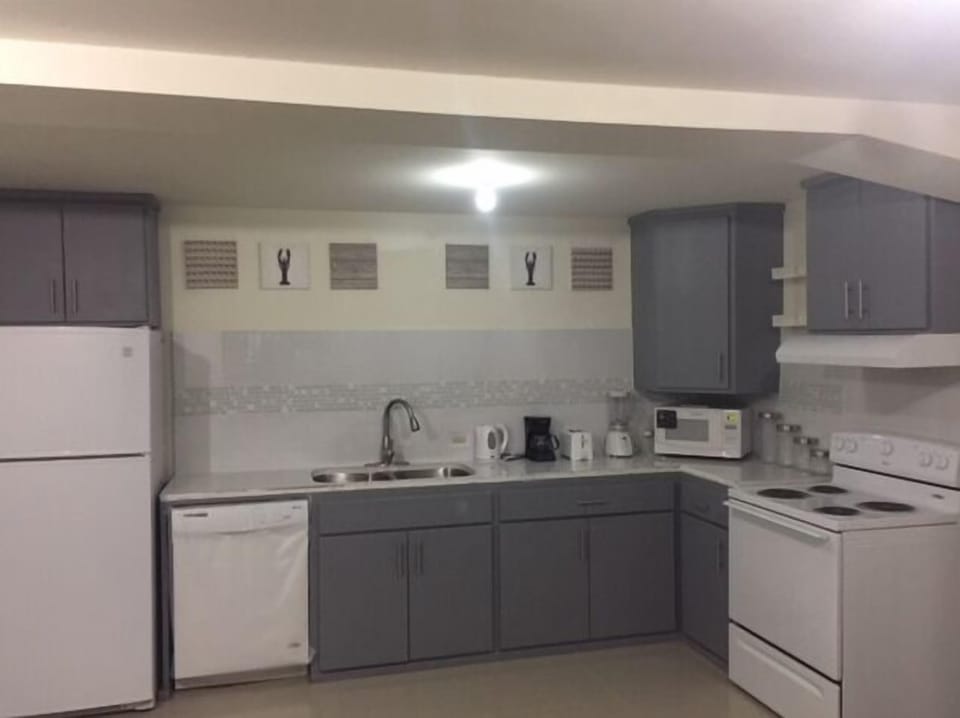 Fully loaded kitchen. dishwasher, microwave, stove, coffee maker, kettle.