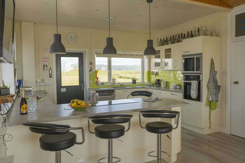 Breakfast bar houses induction hob. 4 Adjustable bar stools for informal dining