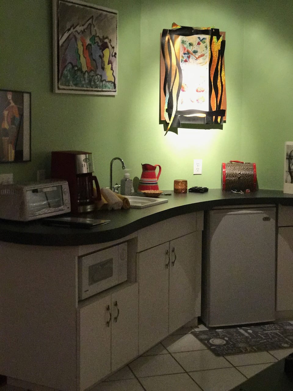 Small Refrigerator, microwave, toaster oven, coffee pot, and sink. 
