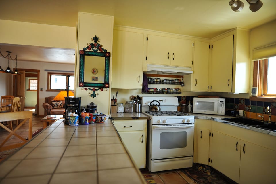 kitchen counter with Mexican mirror, stove with spice rack