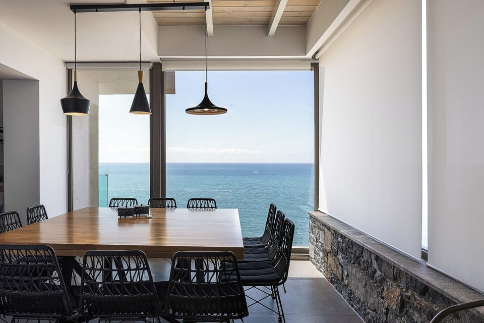 Windows behind dining table bring in sea views.