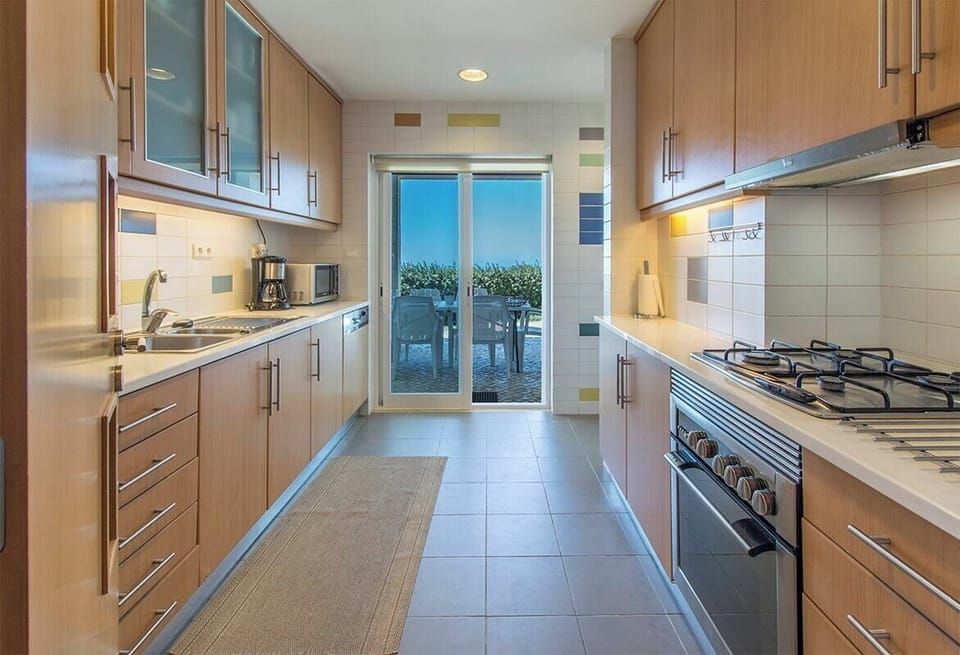 Modern galley kitchen with gas range and terrace access — Villa Foz, luxury holiday villa in Sesimbra