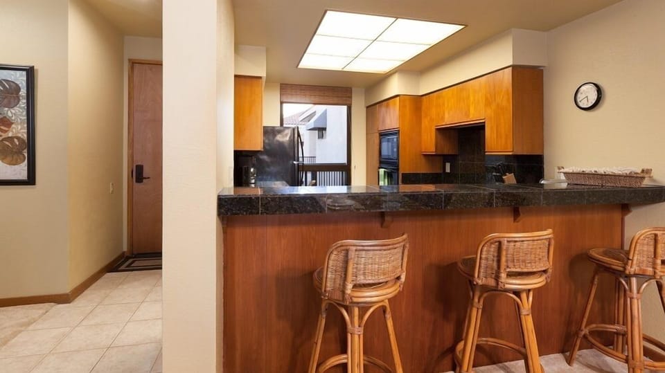 Full kitchen with breakfast bar, granite counters and modern appliances