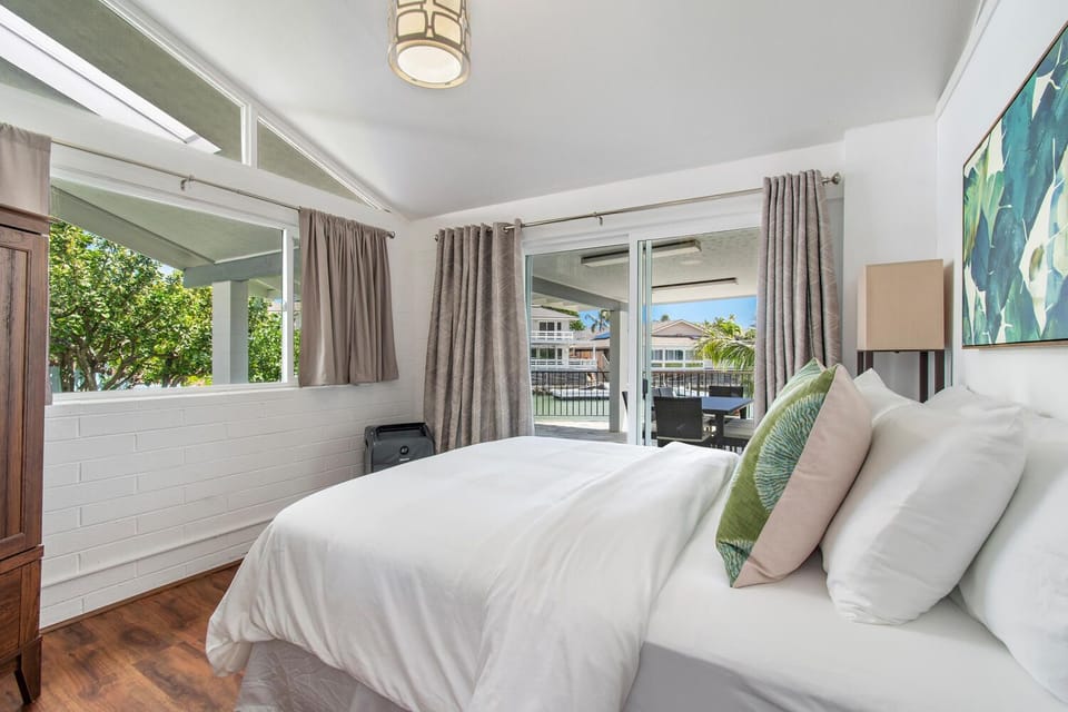 This spacious bedroom with a queen bed and serene marina views makes for a restful stay in paradise.
