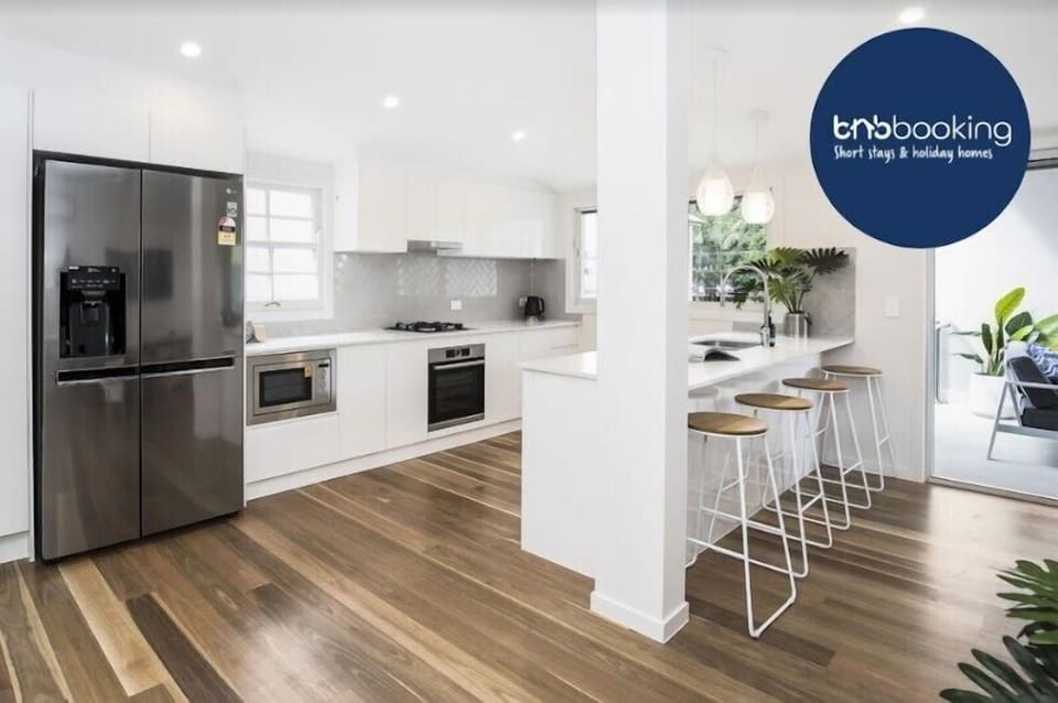 Kitchen with Bosch appliances, large fridge with ice maker, breakfast bar.