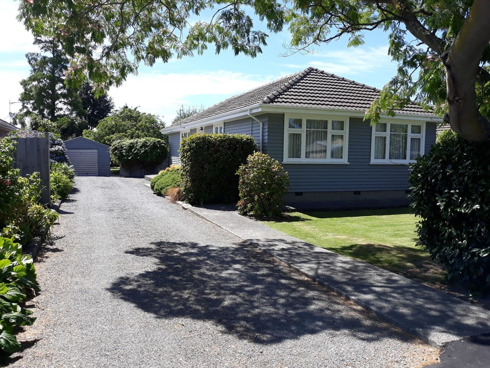 Front of house with drive, garage and entrance to large secluded backyard