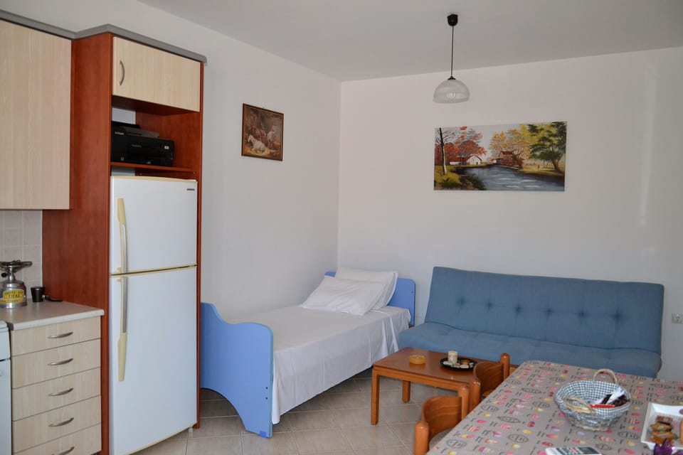 The living room offers a kitchen area, dining table, 2 sofas and coffee table