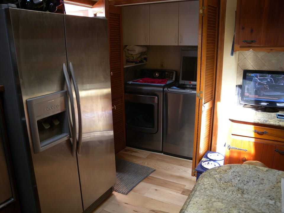 Washer and Drier in kitchen area with bi-fold doors.
