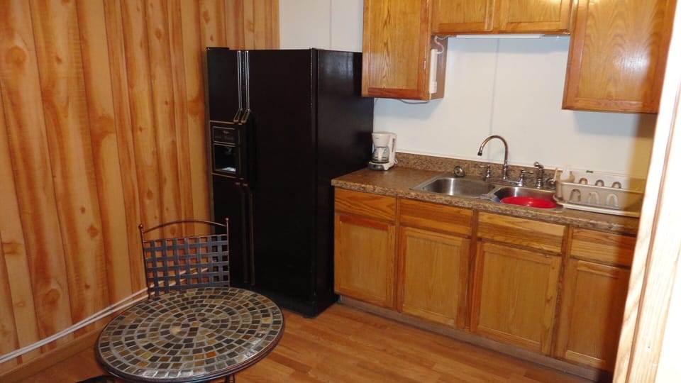 "Bunk House" Kitchen with refrigerator, sink, and eating & cooking utensils.