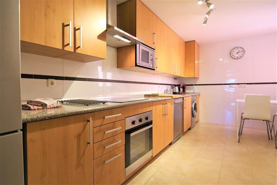 Modern and large kitchen is fully equipped and has an extra table with four chairs
