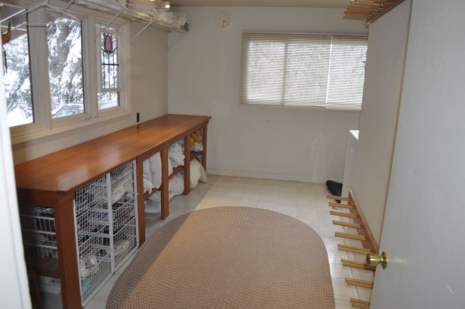 Laundry/ski room with large bench and ski racks.
